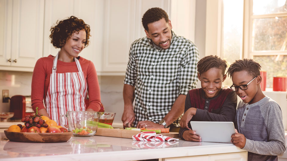 Familia en la cocina mirando televisión